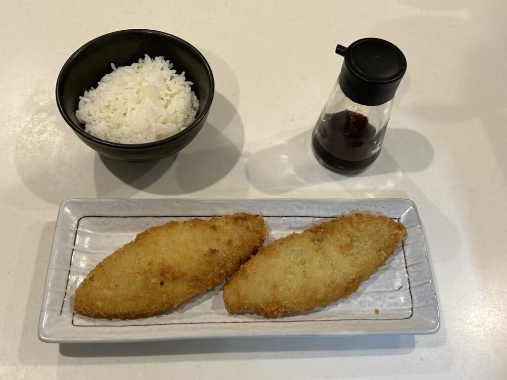 あげた後の白身フライとご飯、醤油差しの写真